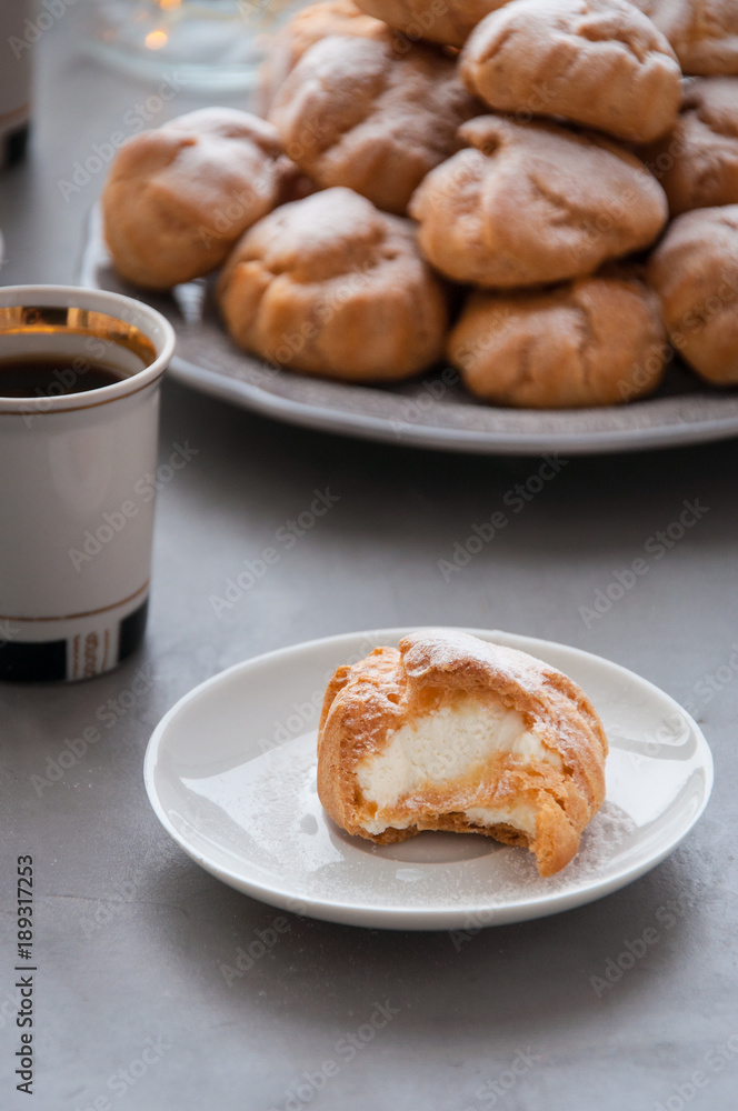 On the table there is a plate of profiteroles, a sweet dessert for breakfast