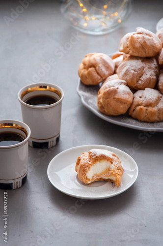 On the table there is a plate of profiteroles, a sweet dessert for breakfast