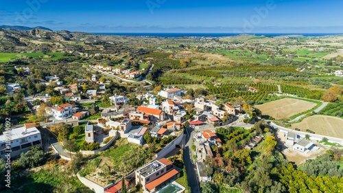 Aerial bird eye view of Goudi village in Polis Chrysochous valley, Paphos, Cyprus. View of traditional ceramic tile roof houses, church, trees, hills and Akamas - Latchi beach bay from above. © f8grapher