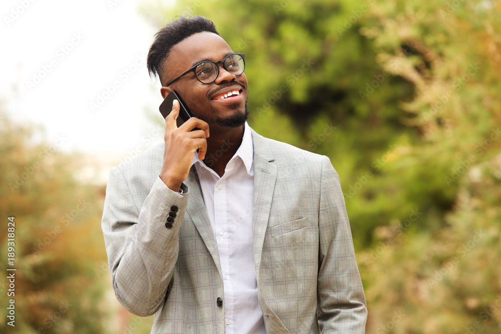 african american businessman walking and talking with mobile phone african american businessman walking and talking with mobile phone