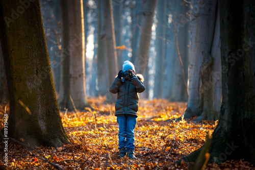 Boy using digital camera taking photo in the nature, hobby concept © leszekglasner