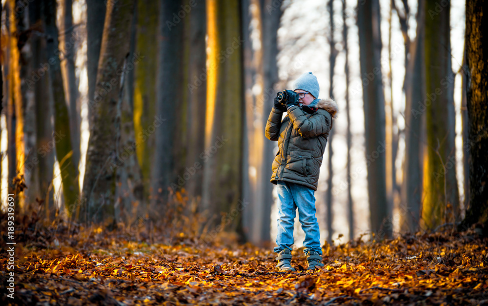 Boy using digital camera taking photo in the nature, hobby concept