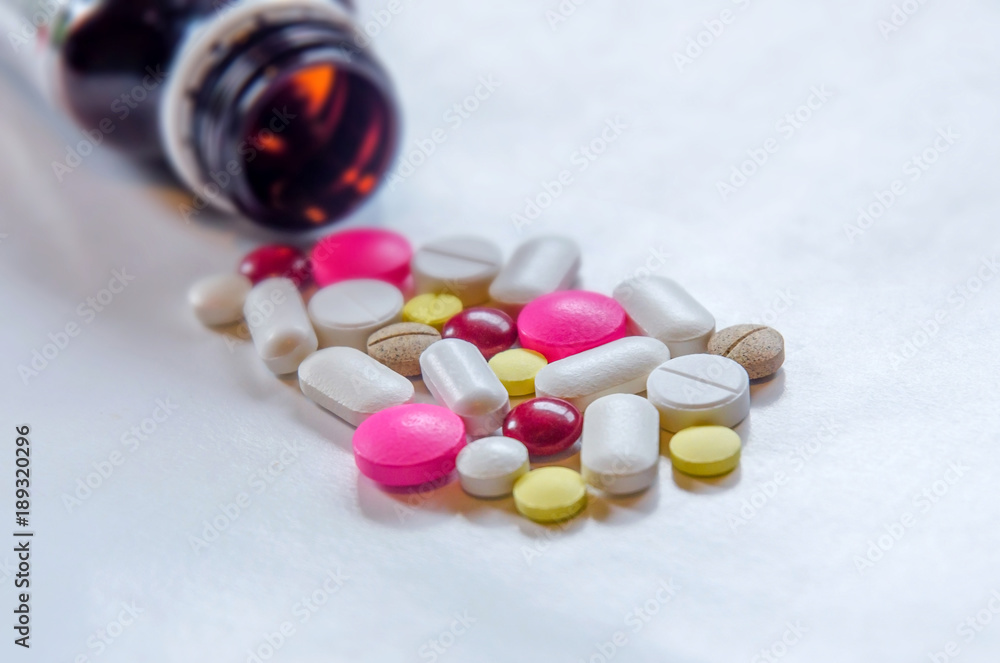 Close-up of the pills on the white background, The drug and capsule pills on the floor, Pile of the drug and pills on the white background. Close-up of the pills on the white background, The drug and capsule pills on the floor, Pile of the drug and pills on the white background.