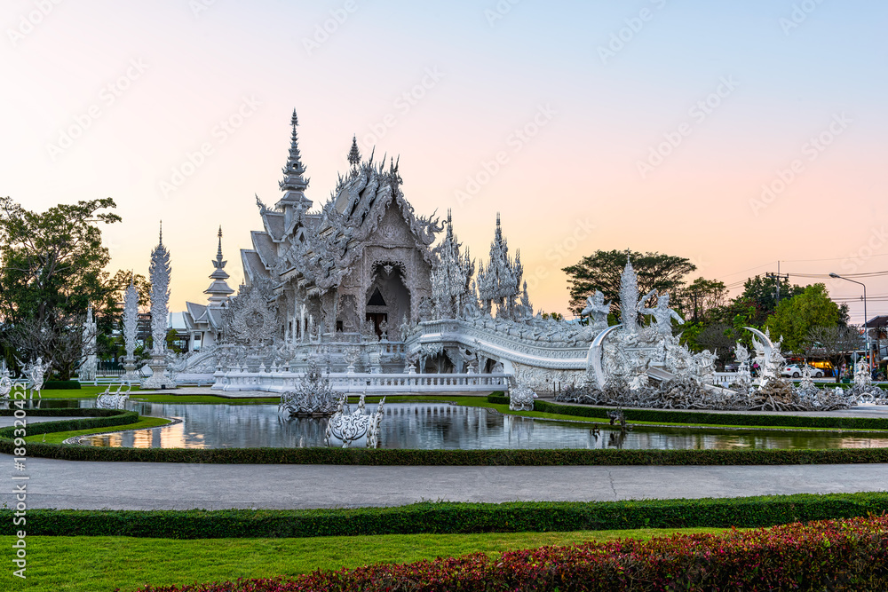 Fototapeta premium Wat Rong Khun(White temple)at sunset in Chiang Rai,Thailand.23/01/2018 Wat Rong Khun is modern building, well known worldwide.It was designed by Chalermchai Kositpipat.Opened it to visitors in 1997.