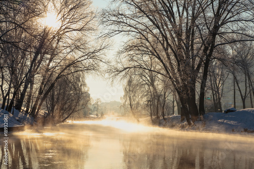 Winter beautiful landscape. Steam rising above the water of the river on a frosty Sunny day.