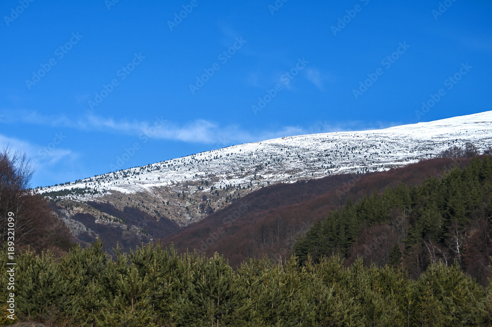 Mountain landscape and country road on clear sunny winter day