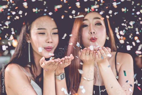 celebration party group of Two asian young  women people holding confetti happy and funny concept. In 2018 New year holiday.