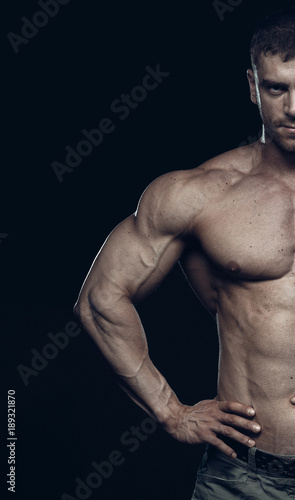 Male bodybuilder, fitness model trains in the gym