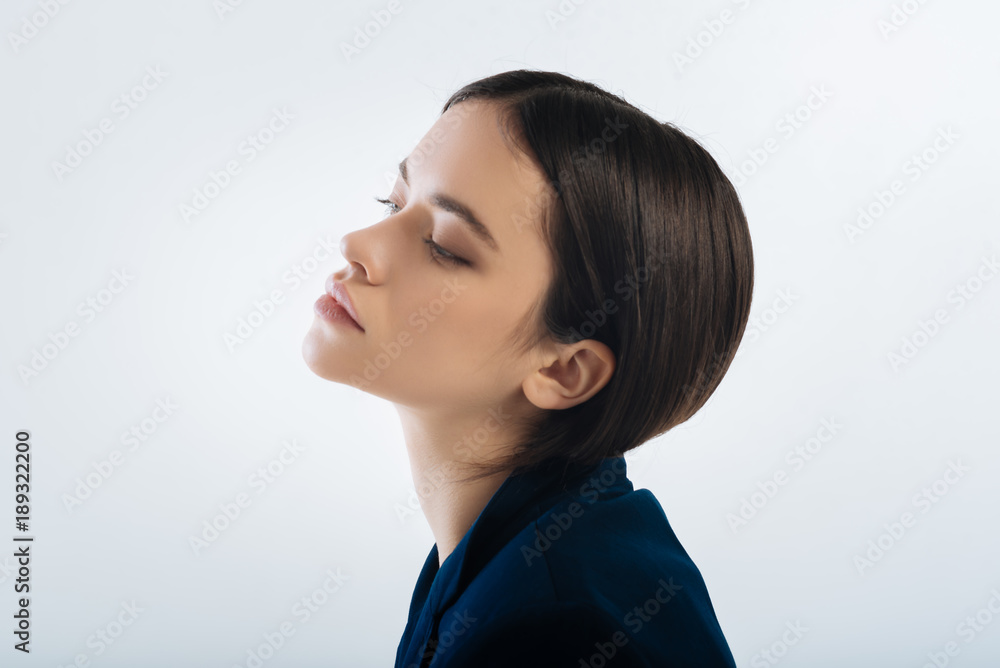 Reflective mood. Brunette musing earnest woman posing in profile while closing eyes and emerging in the thoughts Reflective mood. Brunette musing earnest woman posing in profile while closing eyes and emerging in the thoughts