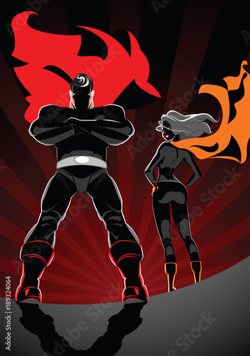 2609534 Superhero Couple: Male and female superheroes on a skyscraper roof with sunlight city background