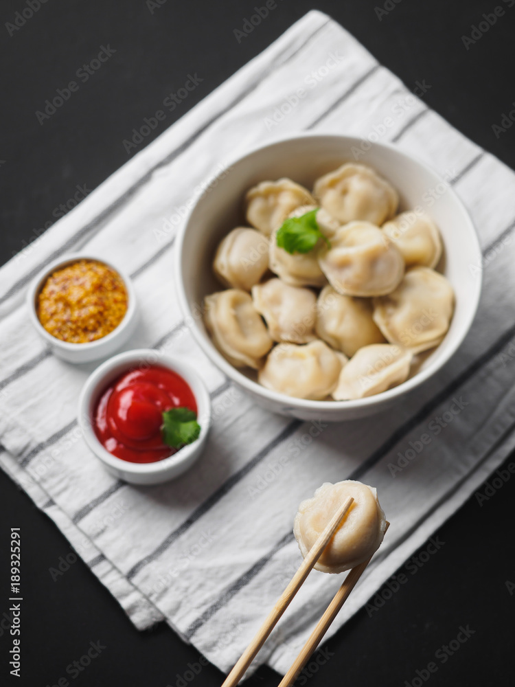 Dumplings on plate at wooden desk on black background Dumplings on plate at wooden desk on black background