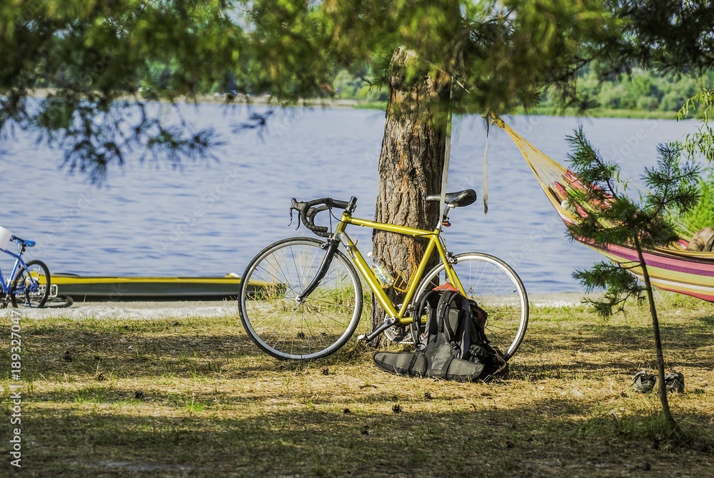 male cyclist, hammock, rest, sunrise and lake or river background