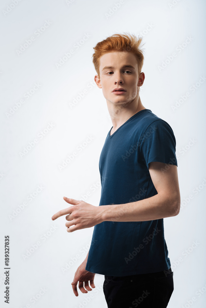 Unexpected meeting. Interesting pensive young guy gesturing and turning while looking down Unexpected meeting. Interesting pensive young guy gesturing and turning while looking down