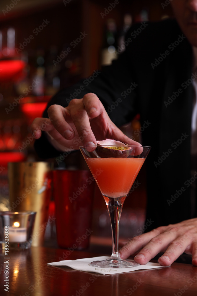 barman preparing a passion fruit cocktail barman preparing a passion fruit cocktail