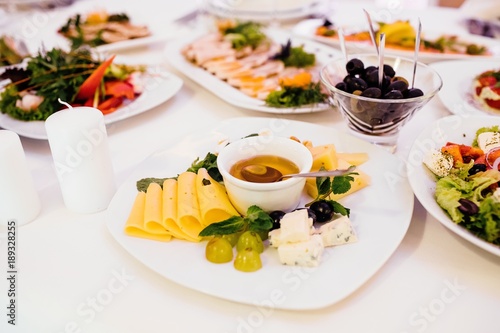 Photo of cheese platter and salad on the table