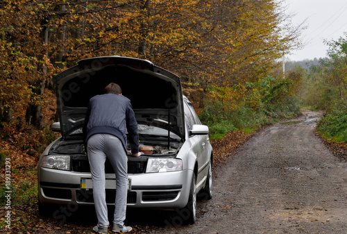 Men spection He opened the hood Broken car on the side See engines that are damaged or not. photo