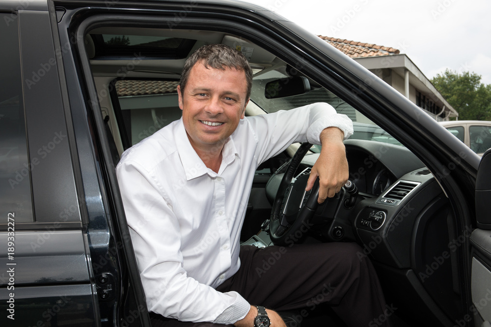 cheerful businessman gets into his car in england cheerful businessman gets into his car in england