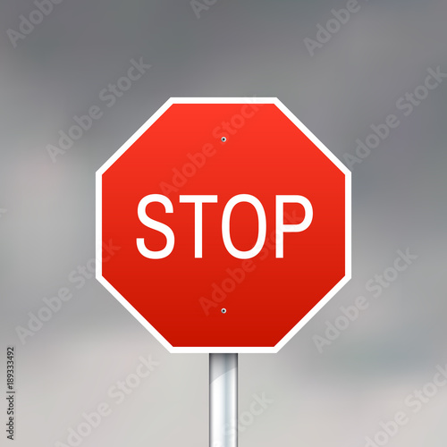 Red stop sign on gray sky background