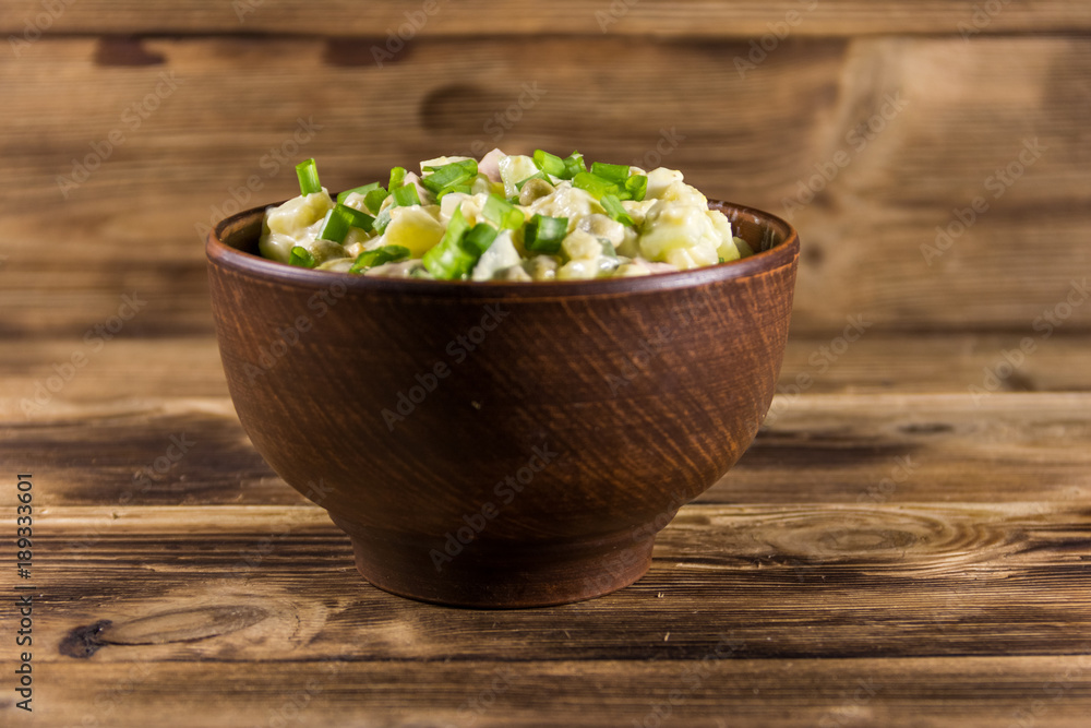 Traditional Russian festive salad Olivier on wooden table Traditional Russian festive salad Olivier on wooden table