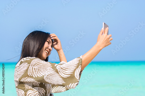 Asian women selfie herself on the beach. Asian women happy for travel on weekend. Asian women smile for take a photo.