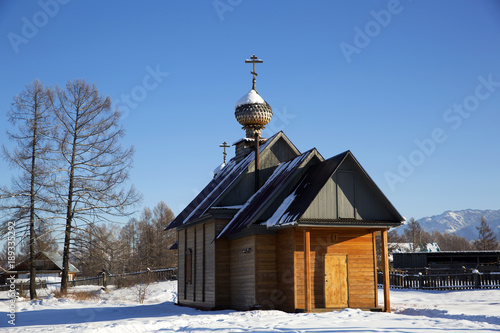 A small church in russian village Zamulta in winter in Uimon Valley, Altai mountains. photo