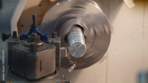 Foto Threading of metal parts on the lathe machine at the factory, lots of metal shav
