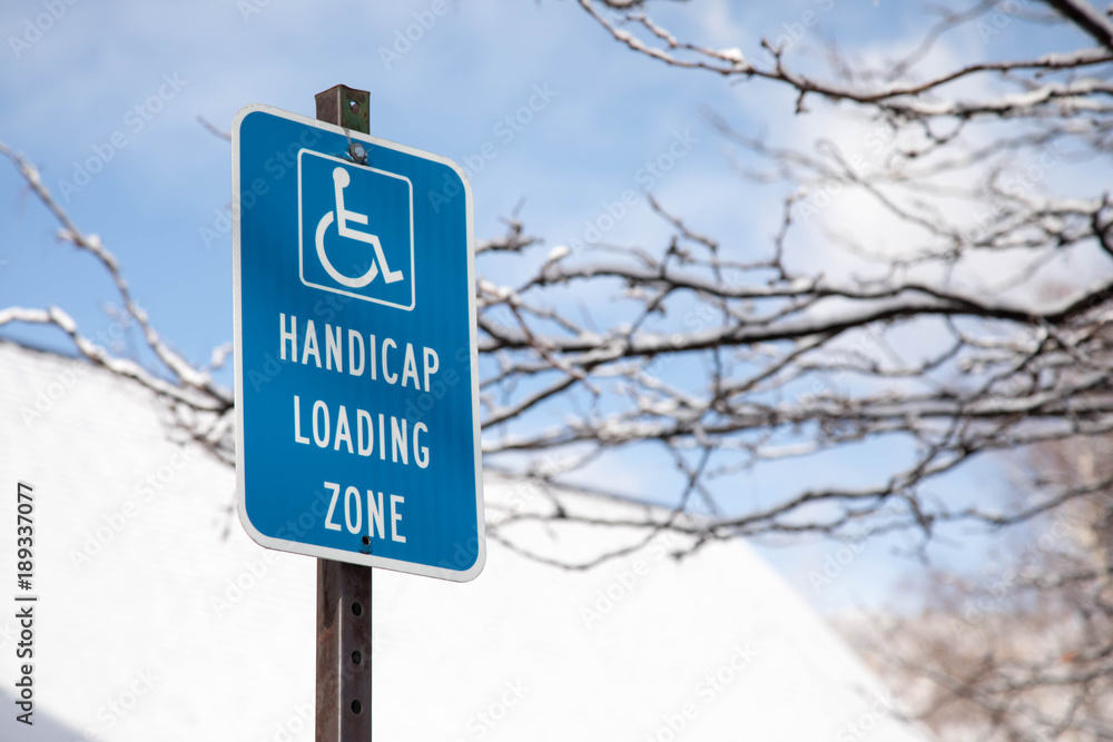 Blue handicap loading zone sign in the winter