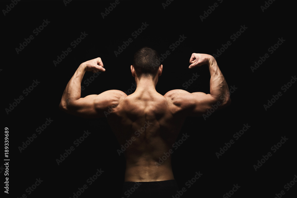 Unrecognizable man shows strong back muscles closeup Unrecognizable man shows strong back muscles closeup