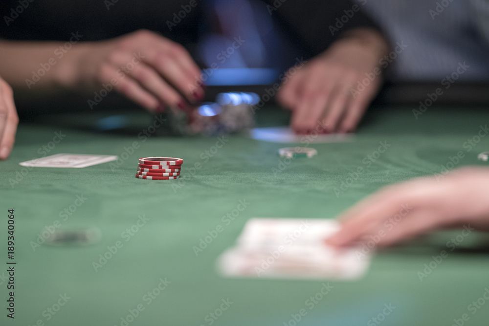 Hände mit karten und chips bei einer Pokalrunde am grünen Tisch Hände mit karten und chips bei einer Pokalrunde am grünen Tisch