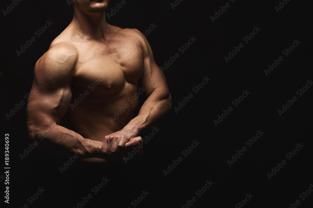 Naklejka premium Silny wysportowany mężczyzna pokazuje nagie muskularne ciało