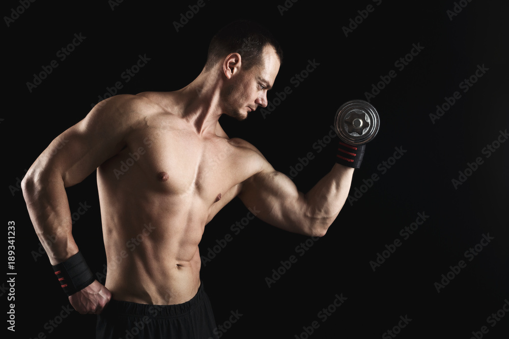Strong athletic man with dumbbell showes naked muscular body Strong athletic man with dumbbell showes naked muscular body