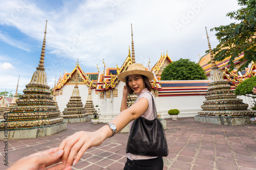 Tourist women with hat sign follow me for travel in temple