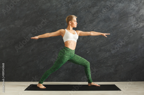 Woman training yoga pose in gym