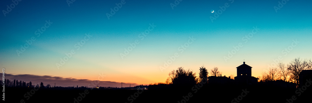 church silhouette at sunset with crescent moon - italian landscape panorama 