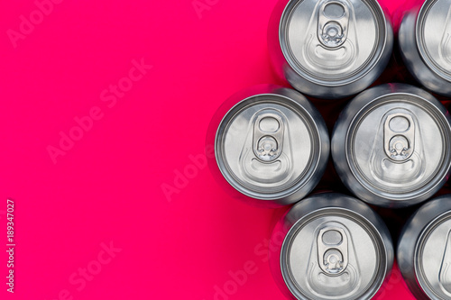 Silver metal energy drinks cans on pink background
