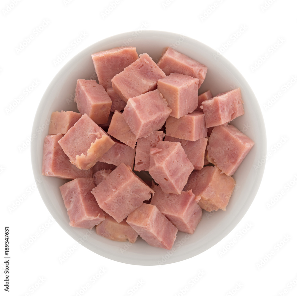 A small bowl filled with canned ham that has been cut into chunks isolated on a white background. A small bowl filled with canned ham that has been cut into chunks isolated on a white background.