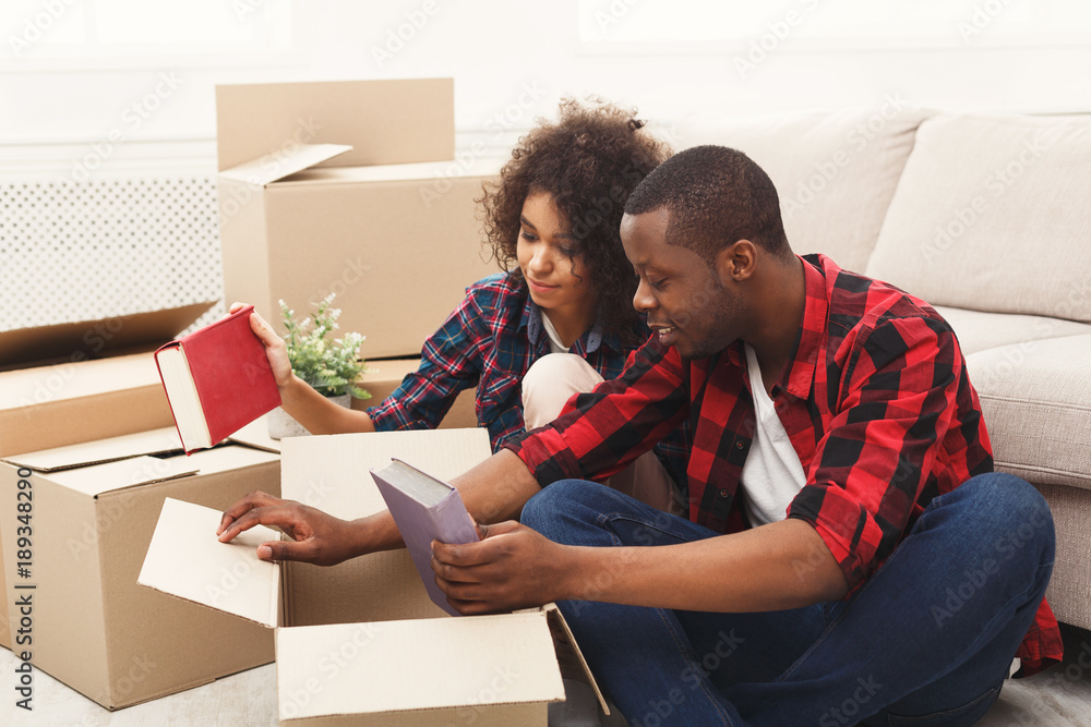 Young balck couple unpacking moving boxes Young balck couple unpacking moving boxes