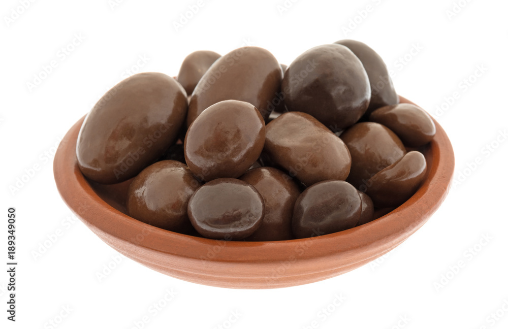 A small bowl filled with bridge mix chocolate candy isolated on a white background. A small bowl filled with bridge mix chocolate candy isolated on a white background.
