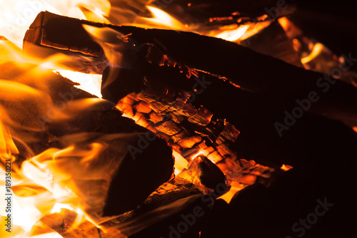 Close up shot of a fire and firewood burning in the fireplace.