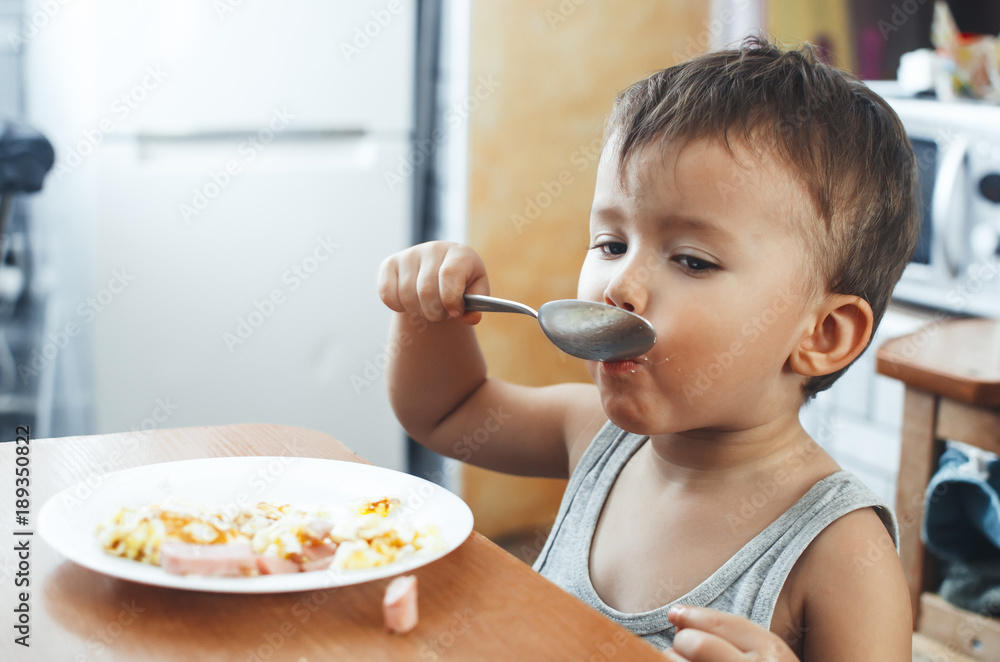 Cute Asian child eating breakfast in a restaurant Cute Asian child eating breakfast in a restaurant