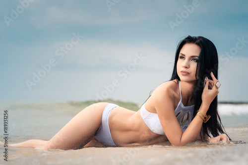 The beautiful girl in bikini on a beach