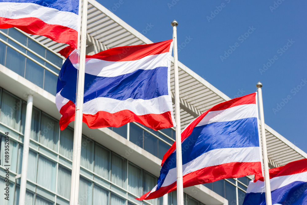 Thai flag with a commercial building background.