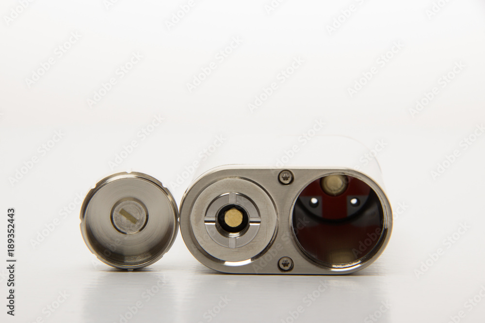 Dismantled parts of the electronic cigarette black and steel colors on a background Dismantled parts of the electronic cigarette black and steel colors on a background