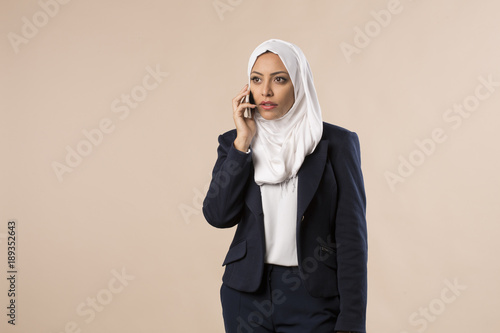 Jeune femme arabe voilée parle au téléphone