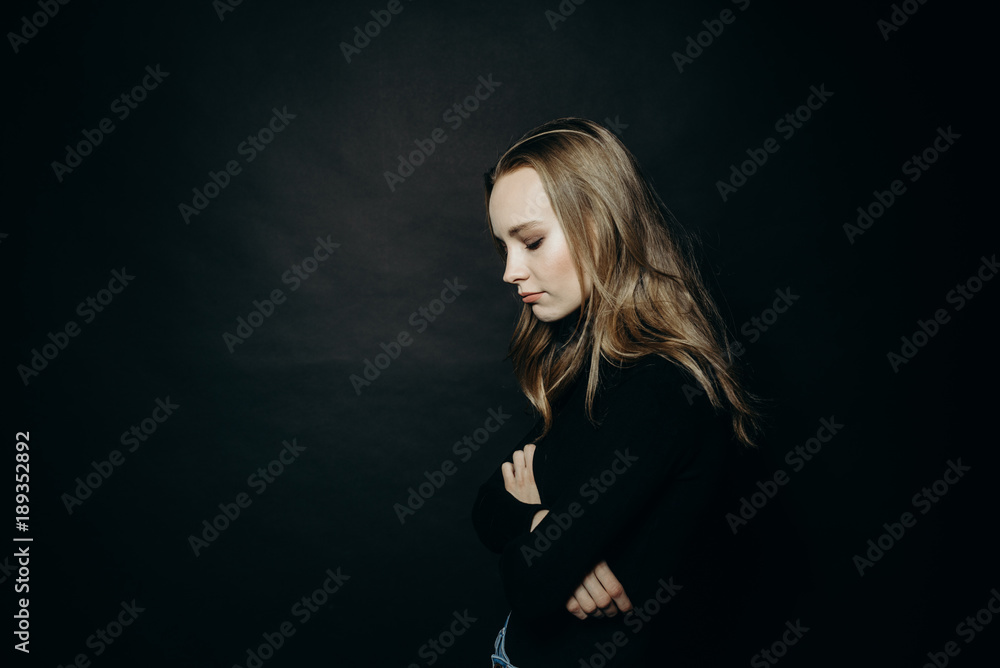 Dramatic portrait. Sad woman in turtleneck on black background. Cute fashionable pretty lady in black sweatshirt, copy space. Dramatic portrait. Sad woman in turtleneck on black background. Cute fashionable pretty lady in black sweatshirt, copy space.