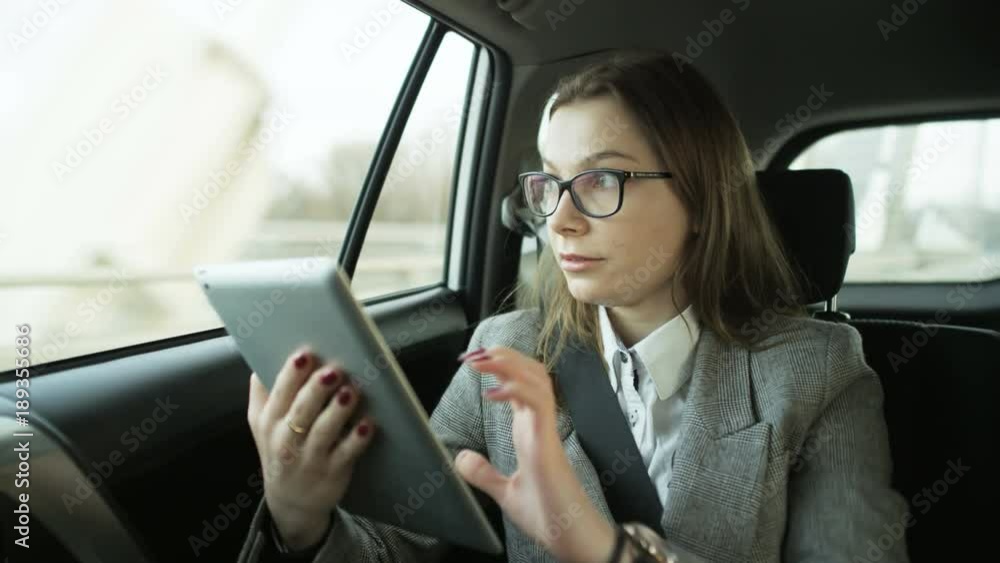 Young Businesswoman Using a Tablet and Checking Hour Young Businesswoman Using a Tablet and Checking Hour