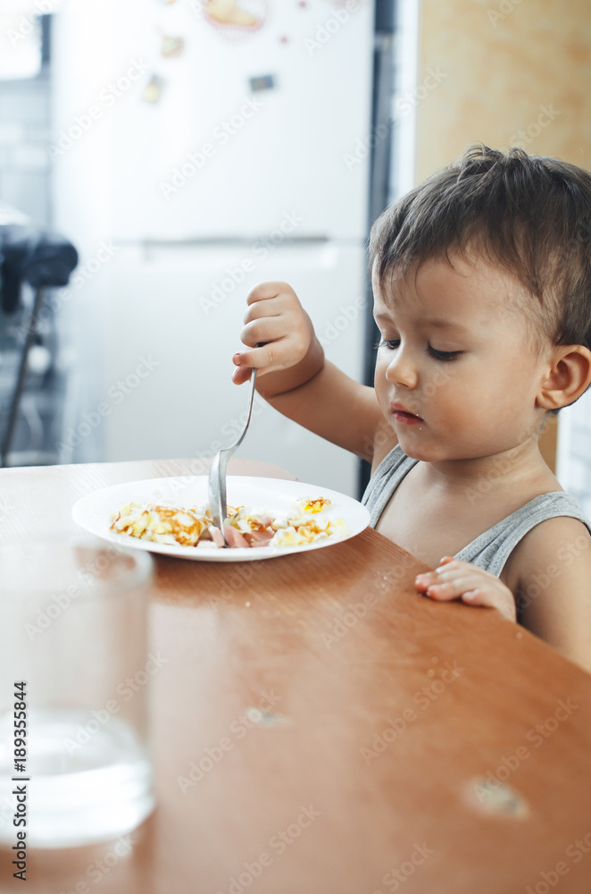 Cute Asian child eating breakfast in a restaurant Cute Asian child eating breakfast in a restaurant