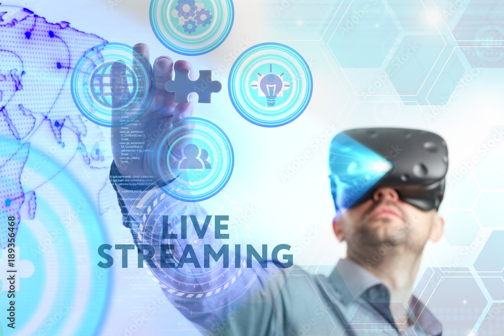 Business, Technology, Internet and network concept. Young businessman working in virtual reality glasses sees the inscription: Live streaming Business, Technology, Internet and network concept. Young businessman working in virtual reality glasses sees the inscription: Live streaming