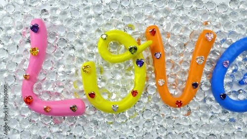 alphabet L in pink color O in yellow color V in orange and E in blue color. the word love in colorful alphabet decorate with diamonds for valentine day.
 photo