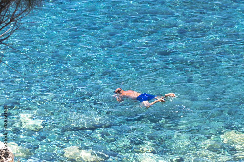 Top view of a man swimming in transparent and crystal clear water Amantea (calabria)